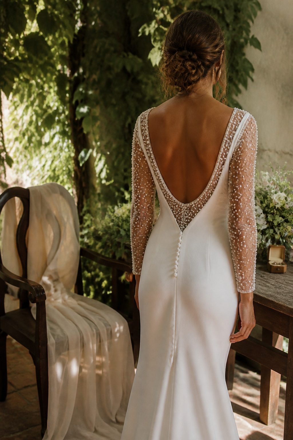 A sheer pearl bodysuit layers under the Alora gown, accentuating its silhouette.