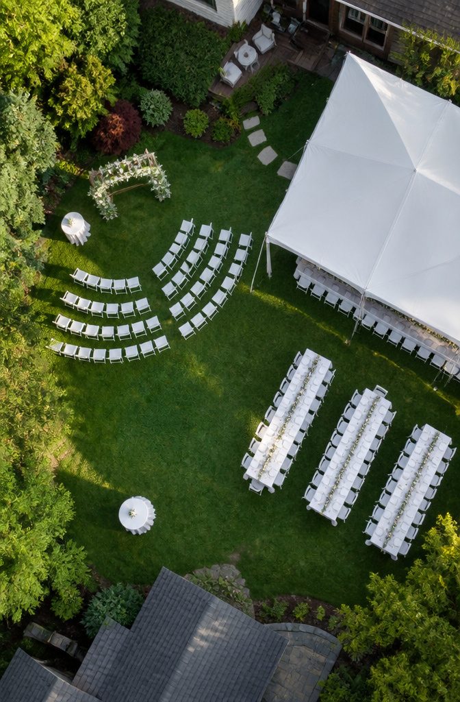 Backyard Wedding Checklist: A Stage-by-Stage Planning Guide 1 A person measuring a suburban backyard with a tape measure.