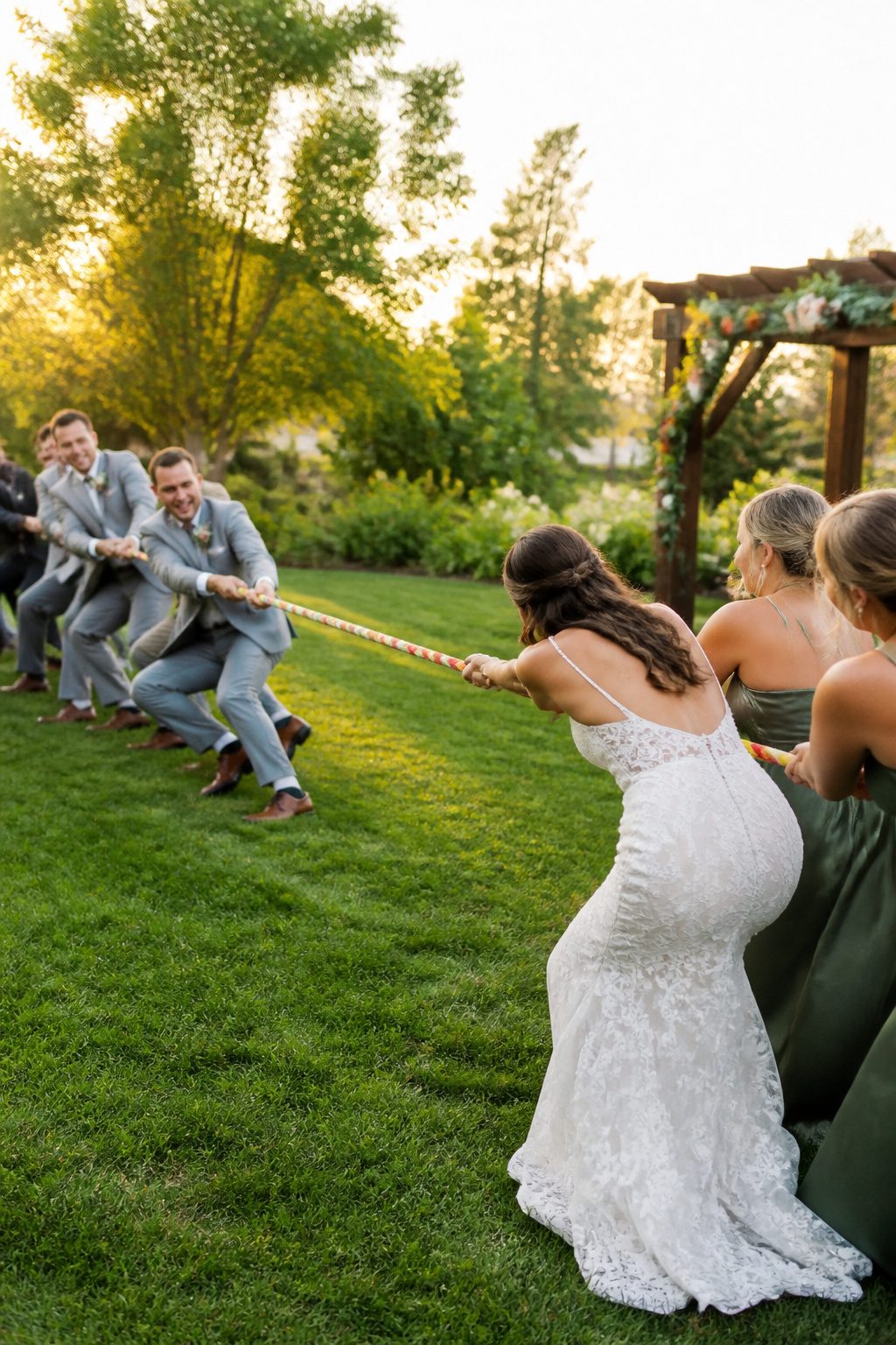 10 Cool Wedding Photo Ideas for Your 2026 Shot List 8 Bridal party engaged in a tug-of-war game outdoors.