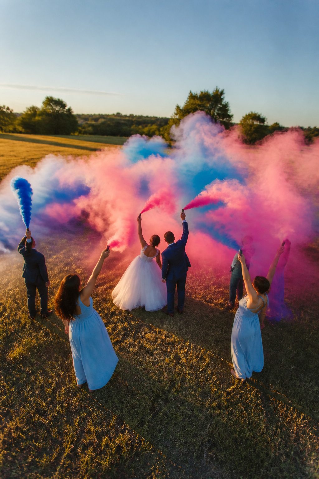 10 Cool Wedding Photo Ideas for Your 2026 Shot List 5 Couple with smoke bombs creating colorful clouds during a photo shoot.