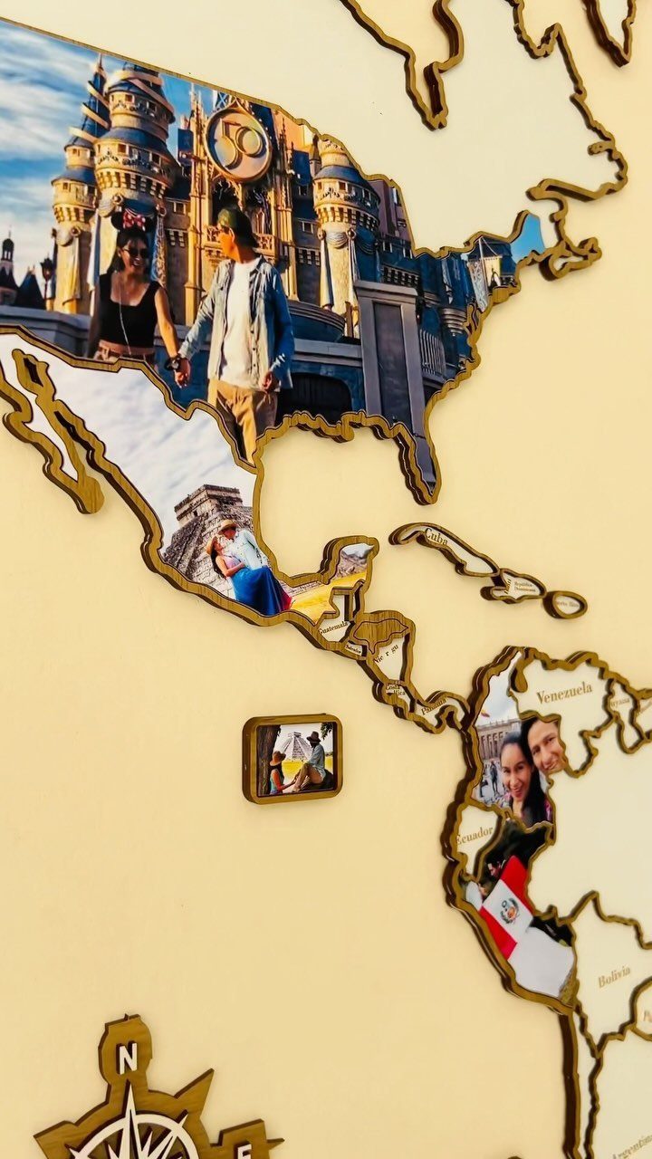 A wooden world map wall decoration featuring various personal travel photographs inside the country shapes.