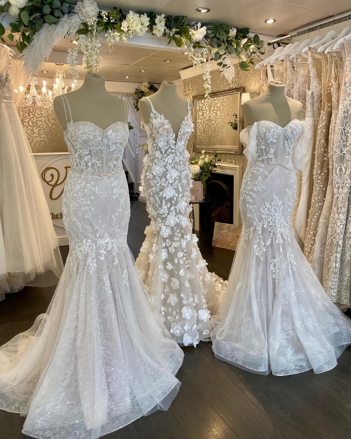 Elegant Mermaid Wedding Dress: 5 Details That Define the Look 2 Three white mermaid wedding dresses displayed on mannequins in a bridal boutique setting.