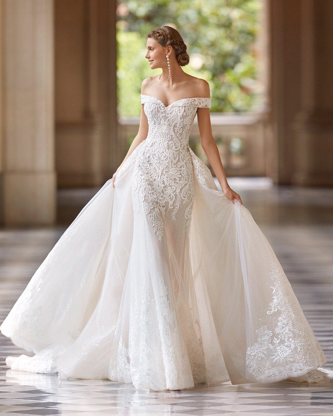 Elegant Mermaid Wedding Dress: 5 Details That Define the Look 4 Woman wearing an ivory lace mermaid wedding dress with a voluminous blush overskirt.