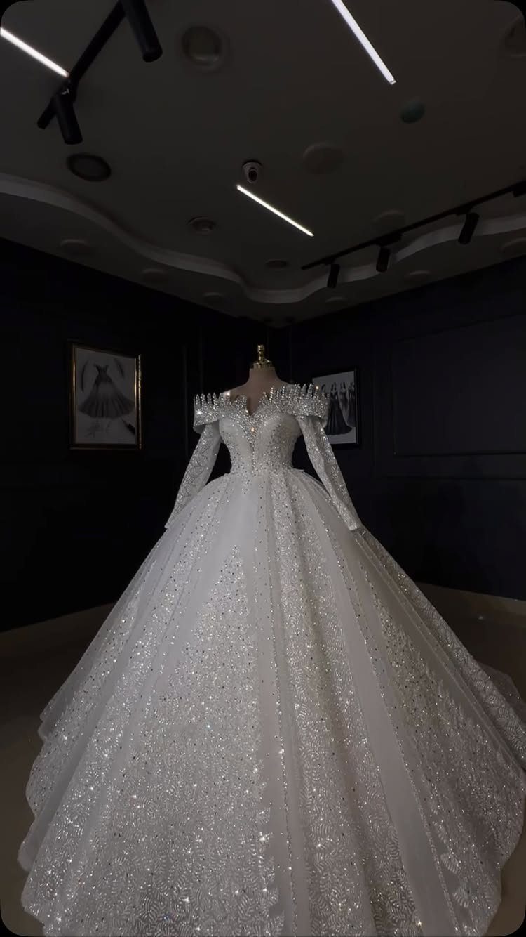 A sparkling white ballgown wedding dress with heavy crystal detailing on a mannequin.