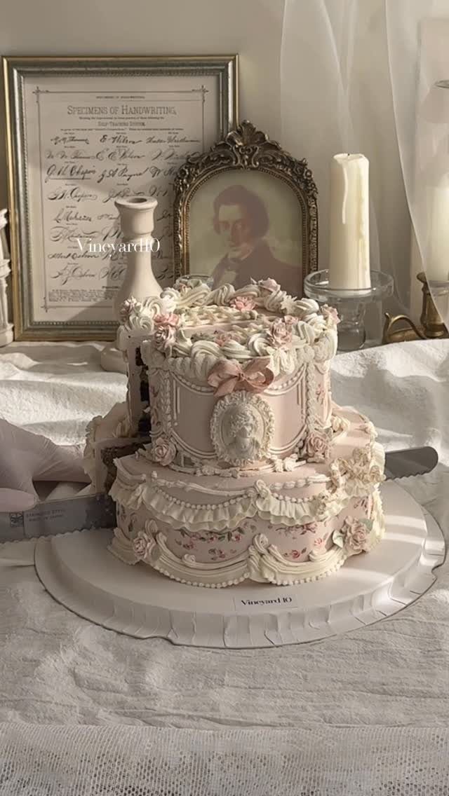 Shabby Chic Wedding: 10 Ideas for Timeworn Charm 5 A two-tiered vintage wedding cake with pink ruffles and roses on a white linen tablecloth.
