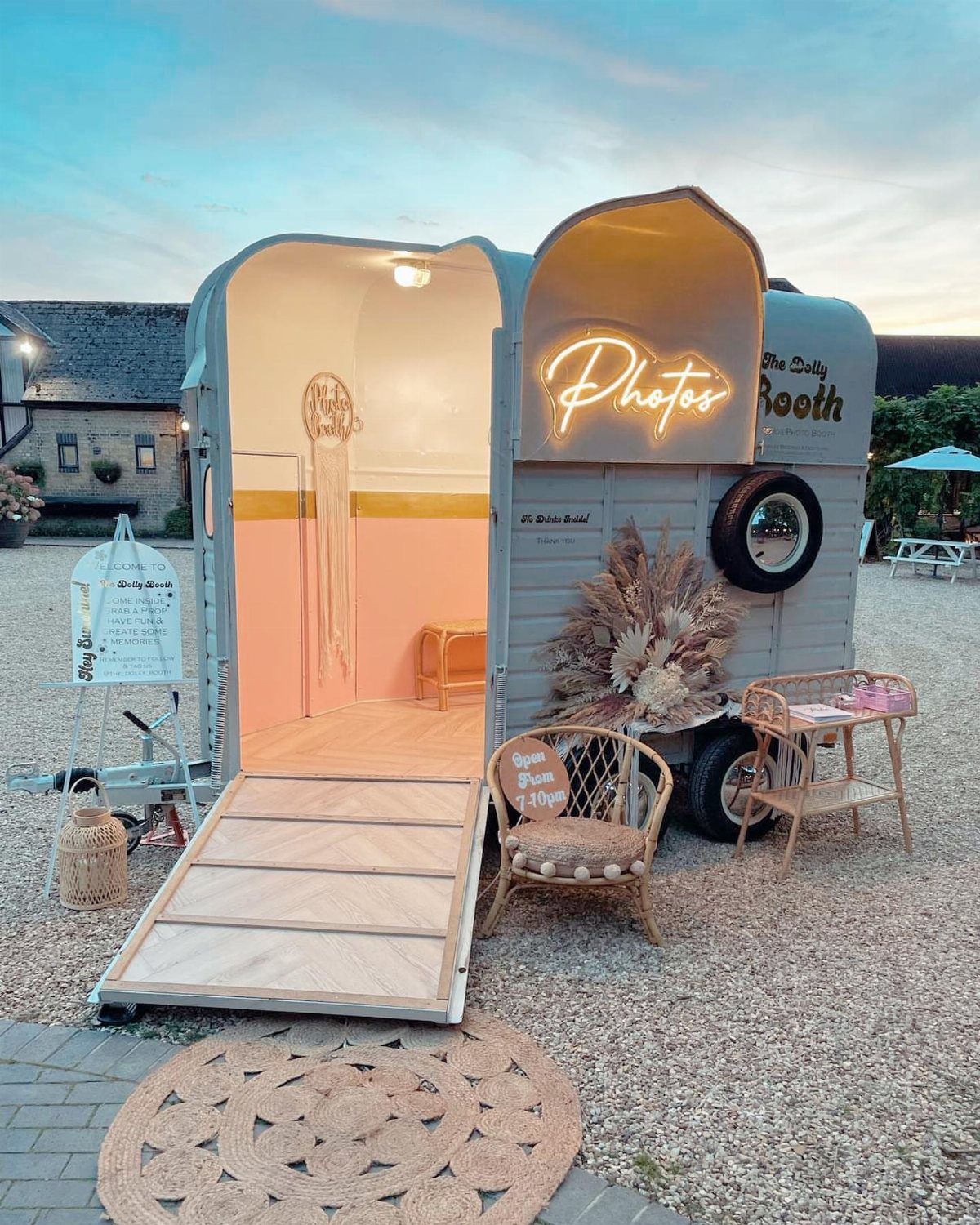 Shabby Chic Wedding: 10 Ideas for Timeworn Charm 2 A vintage converted trailer photo booth with a neon sign and wooden ramp outdoors.