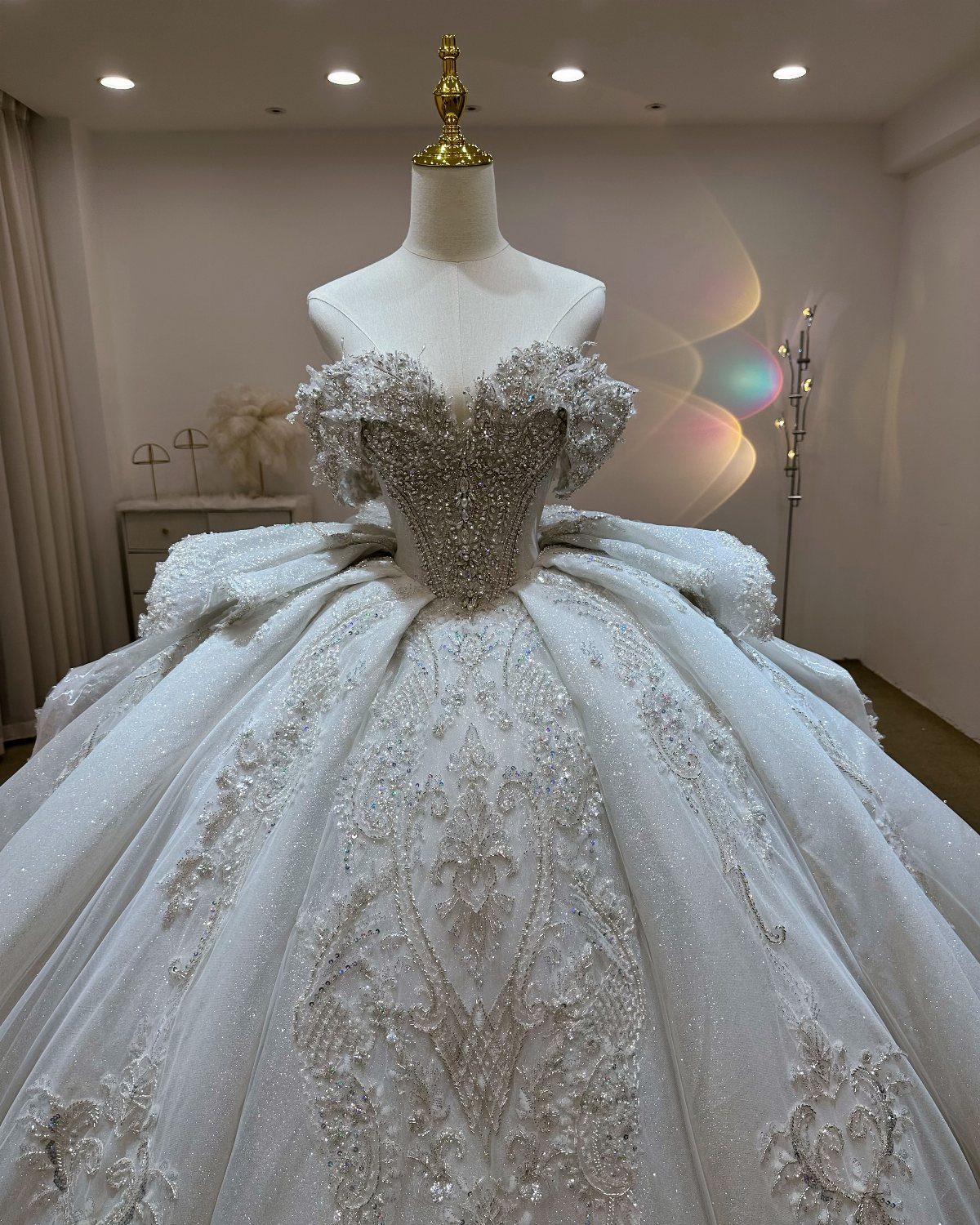 A voluminous white ball gown with a sparkling corset bodice on a mannequin.
