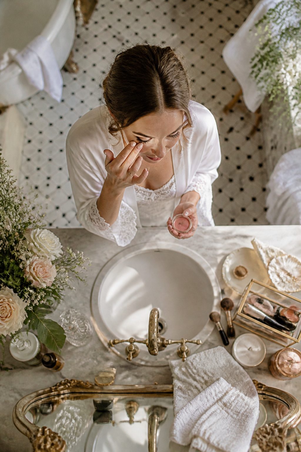 How to Do Very Light Makeup Looks: 11 Steps for a Fresh Face 15 Bride touching up her makeup in a bathroom mirror.