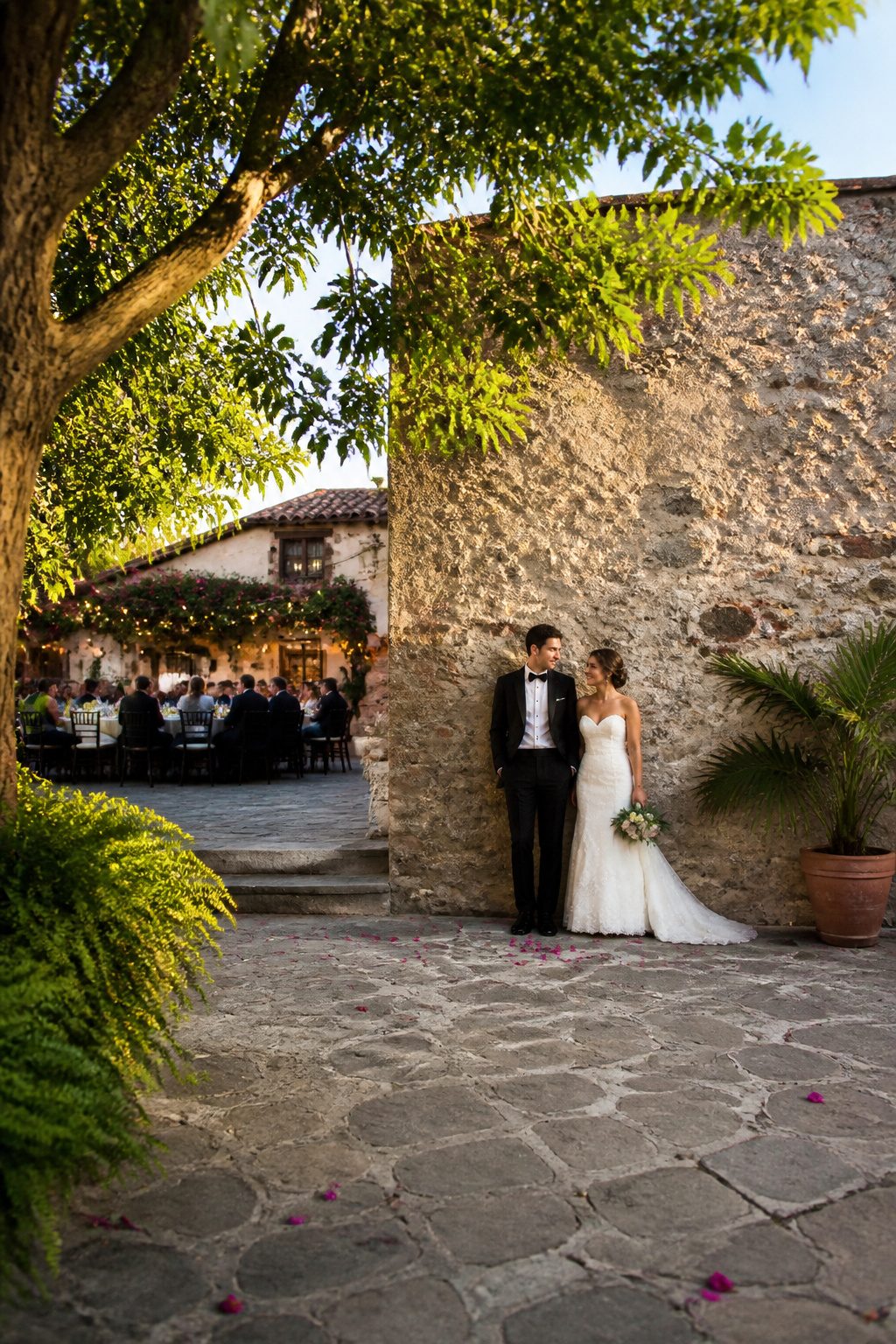 Wedding Couple Photos: Ideas, Planning & Timing in 2026 3 A couple standing by a stone wall at their wedding venue.