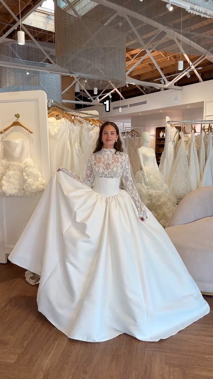 Woman wearing a white wedding dress with a high lace neckline and long lace sleeves.