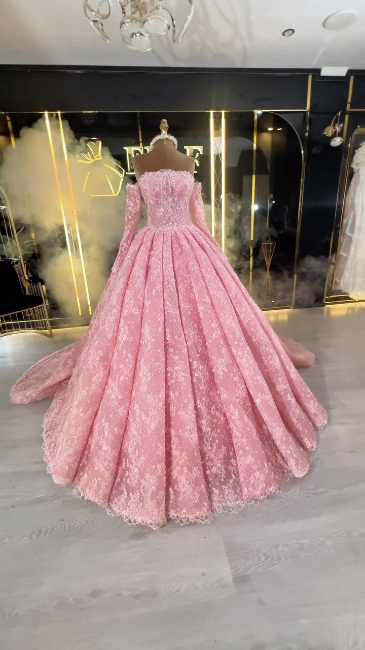 Wedding Dress White and Pink: 8 Gowns for a Colorful Ceremony 2 Pink lace off-the-shoulder gown with silver sequin embroidery displayed on a mannequin.