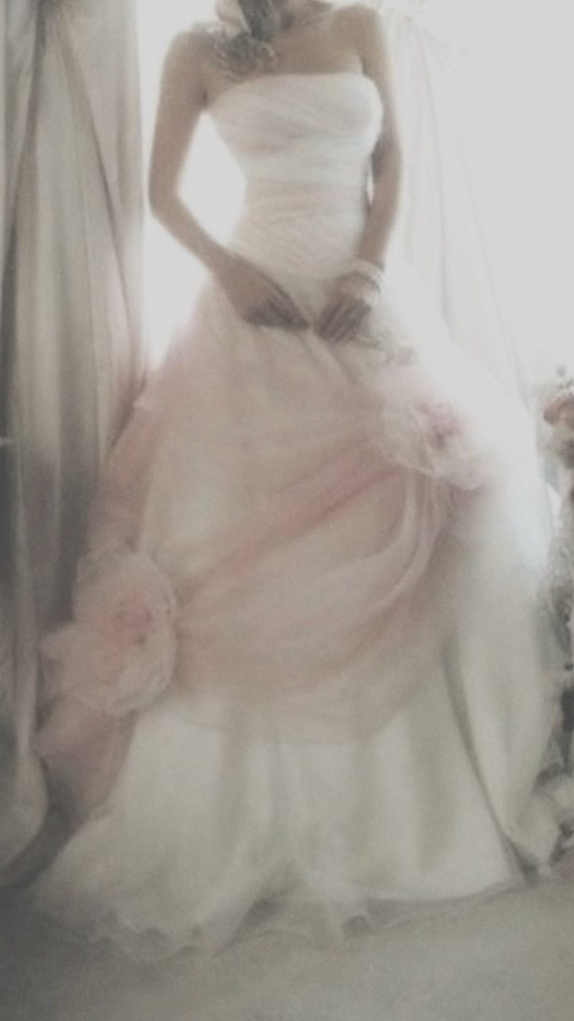 Wedding Dress White and Pink: 8 Gowns for a Colorful Ceremony 8 A woman wearing a strapless white wedding dress with a large pink tulle skirt overlay.
