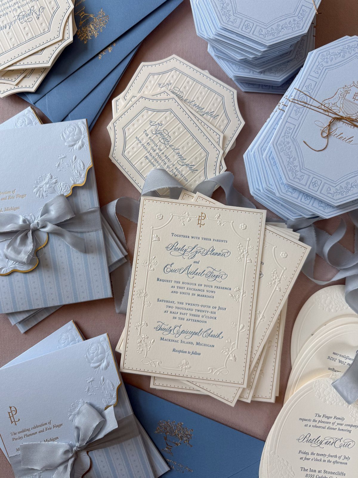 Wedding Invitations with Ribbon: 5 Ideas That Look Handmade 3 Elegant wedding invitations with scalloped edges, calligraphy, and grey silk ribbons arranged in stacks.