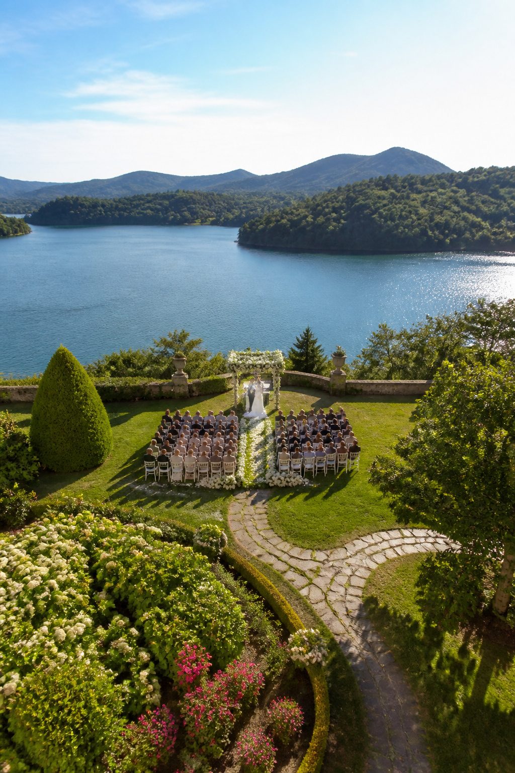 A drone view of a wedding ceremony with guests arranged in rows.