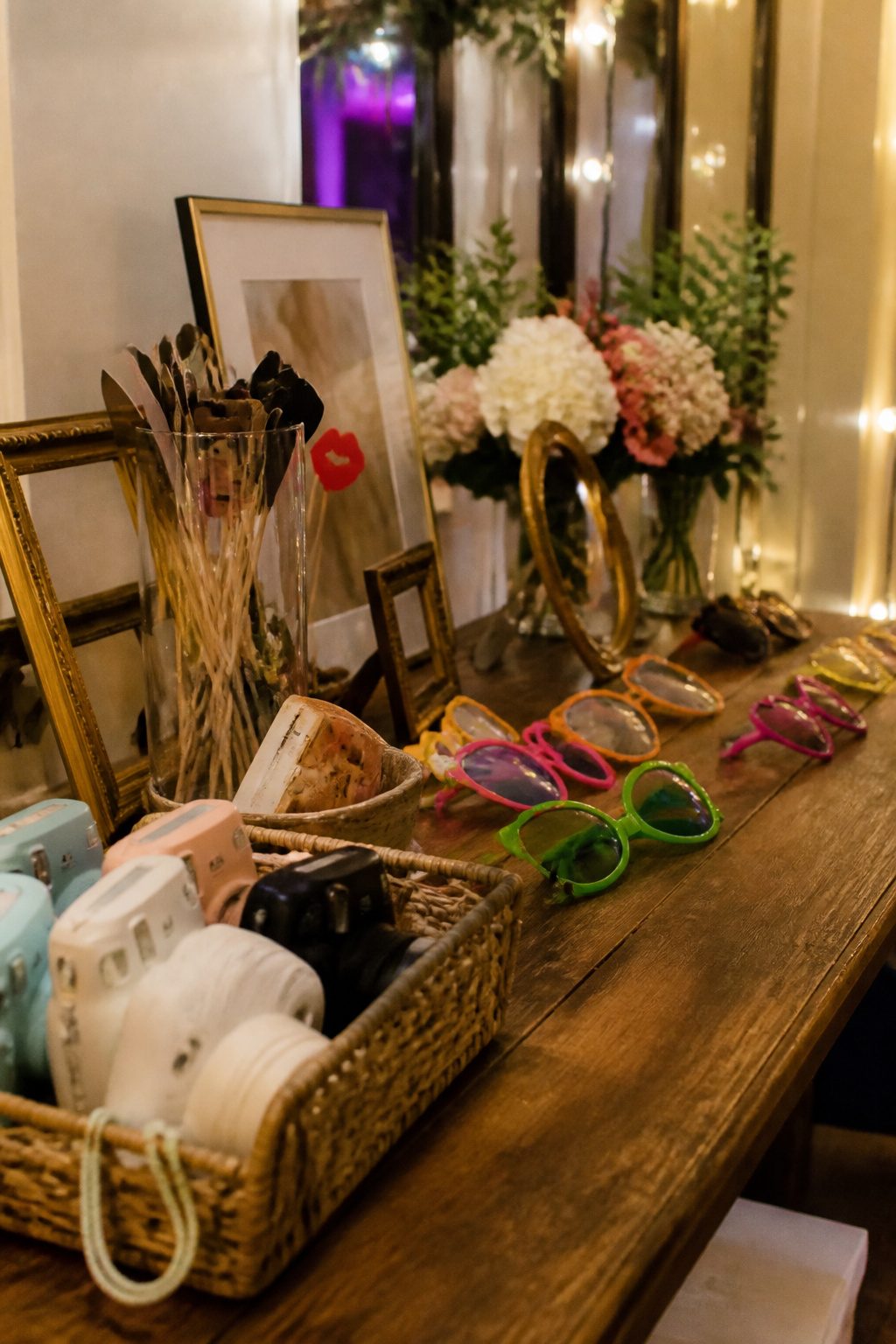 Guests posing with oversized glasses and fun props at a reception table.