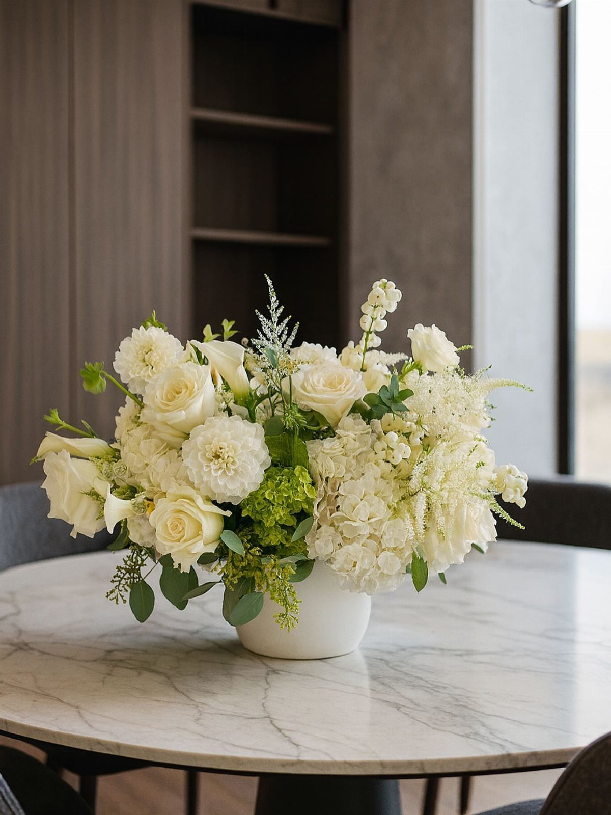 White Flower Centerpieces 5 Ways: From Lily Drama to Daisy Casual 5 White floral centerpiece with roses and hydrangeas in a white vase on a marble table.
